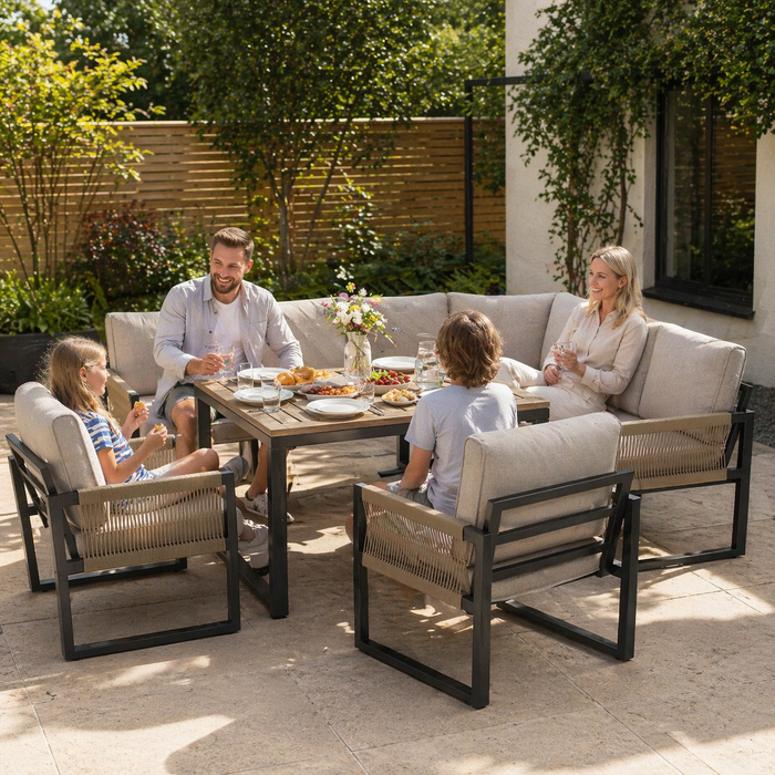 Family of four sitting around a wooden outdoor table in a garden setting