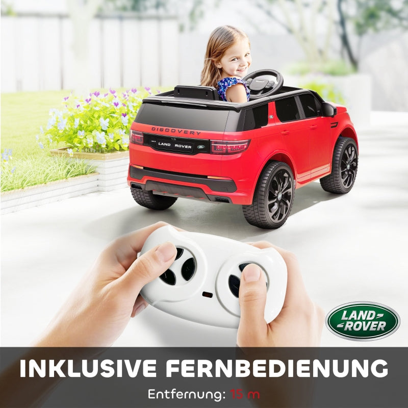 Red toy car with remote control, featuring Land Rover branding, on a white surface.